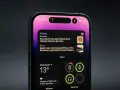 Nowy iPhone z dynamic island, wyświetlający wiadomości i pogodę.