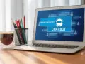 Na ekranie laptopa widać interfejs chatbota, który oferuje pomoc. Obok stoi szklanka kawy i pojemnik z przyborami do pisania.