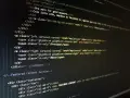 Fragment kodu HTML wyświetlający strukturę strony internetowej na ciemnym tle.