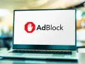 Laptop z logo AdBlock. Dowiedz się, jak wyłączyć adblocka, aby zobaczyć treści.