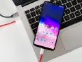Smartfon podłączony kablem do laptopa, gotowy do przenoszenia zdjęć.