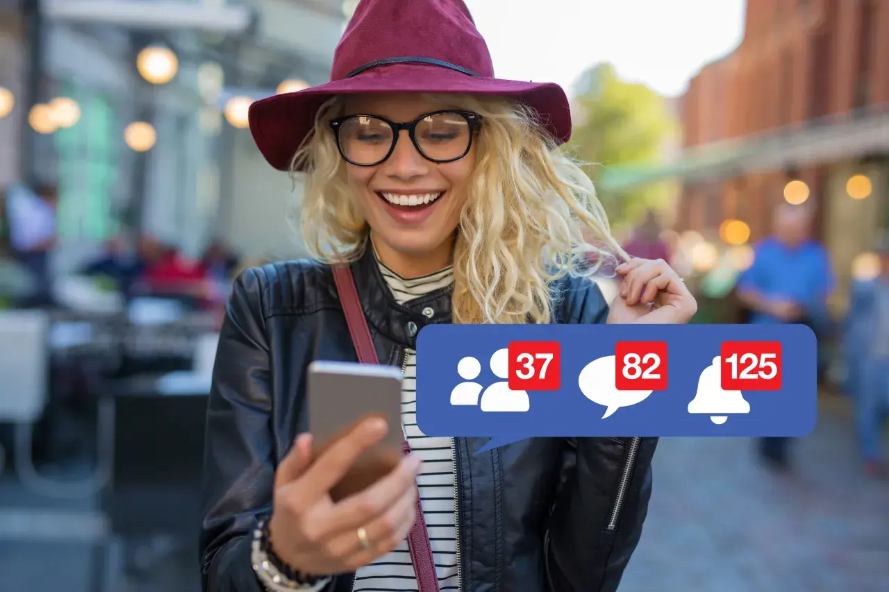 Szukasz informacji, jak usunąć konto na FB na telefonie? Uśmiechnięta dziewczyna z telefonem i powiadomieniami na ekranie.