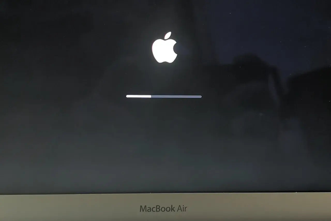 Ekran startowy MacBook Air z logo Apple i paskiem postępu, wskazującym ładowanie systemu macOS Monterey.