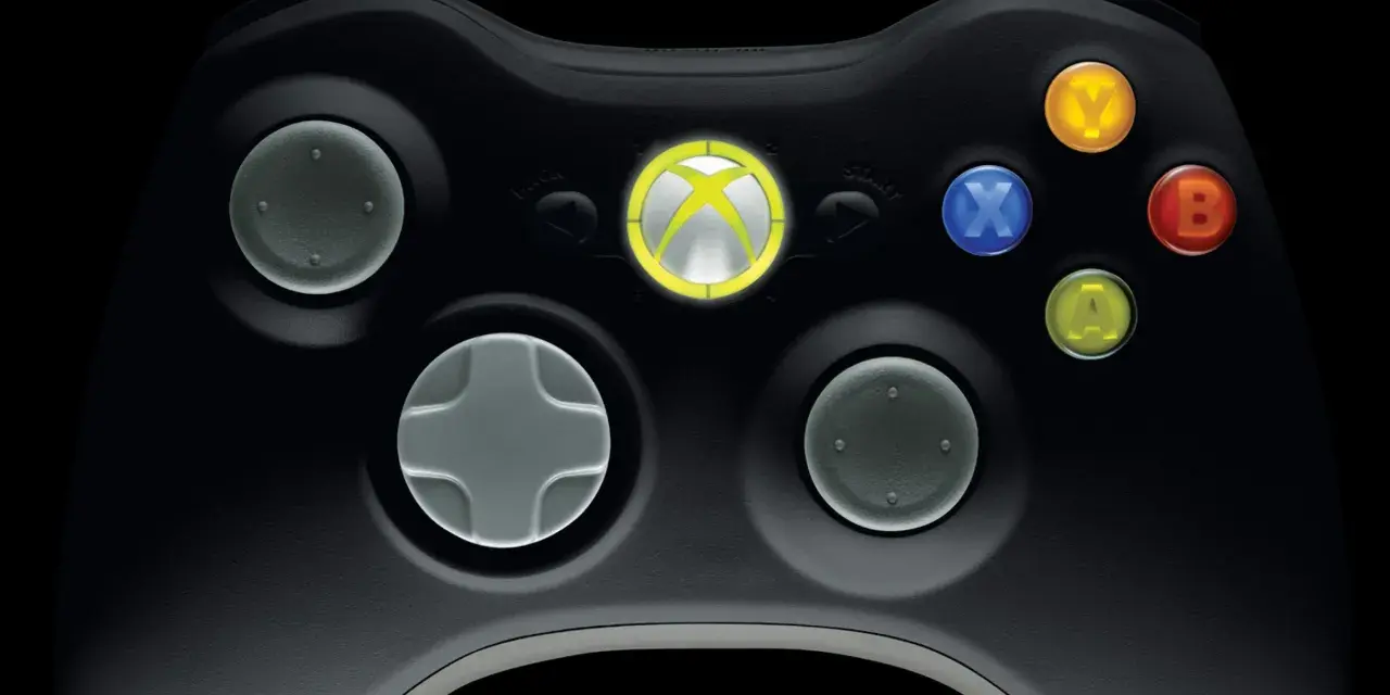 Zbliżenie na czarny kontroler Xbox 360 z podświetlonym logo Xbox i kolorowymi przyciskami.