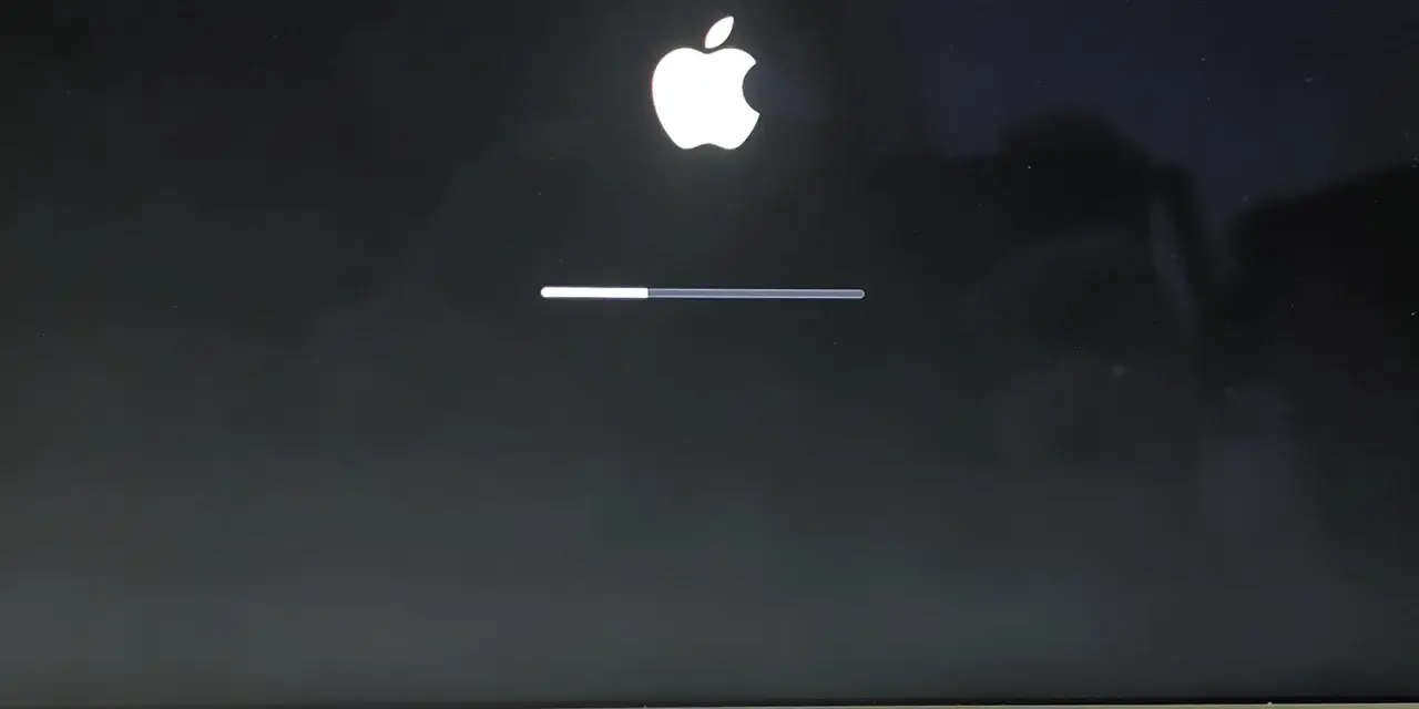 Ekran startowy MacBook Air z logo Apple i paskiem postępu, wskazującym ładowanie systemu macOS Monterey.