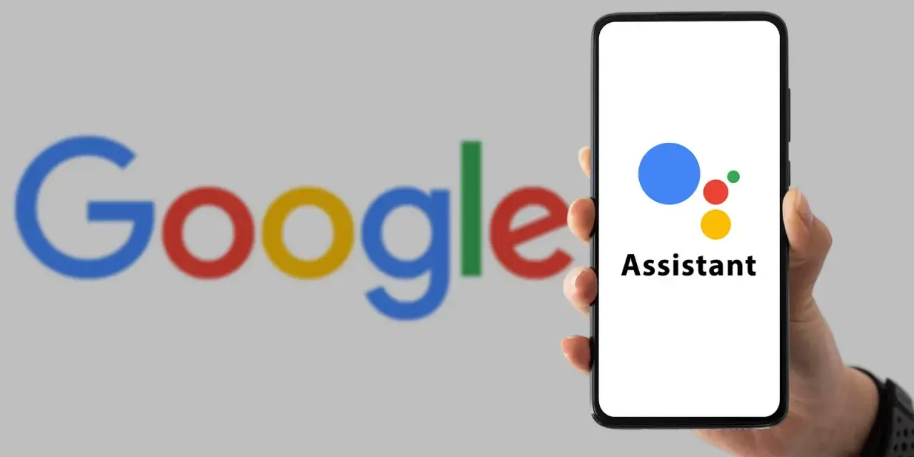 Dłoń trzyma smartfon z logo Asystenta Google na ekranie, w tle logo Google.