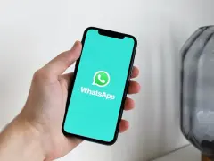 Dłoń trzyma smartfon z ekranem pokazującym logo WhatsApp. Gotowy do pobrania i instalacji.