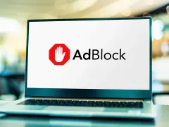 Laptop z logo AdBlock. Dowiedz się, jak wyłączyć adblocka, aby zobaczyć treści.