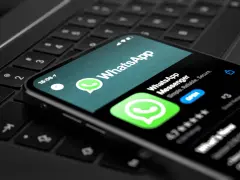 Telefon z aplikacją WhatsApp na klawiaturze laptopa. Teraz możesz korzystać z WhatsApp na komputerze.