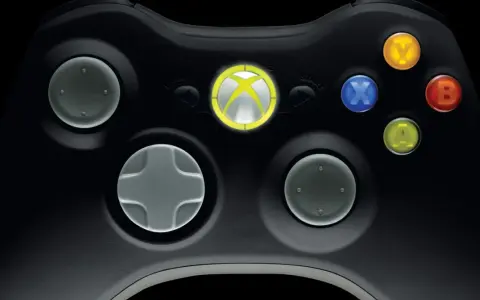 Zbliżenie na czarny kontroler Xbox 360 z podświetlonym logo Xbox i kolorowymi przyciskami.