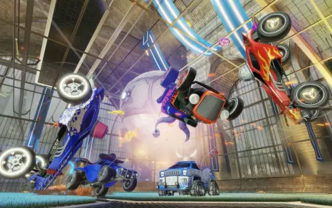 Trzy samochody z gry Rocket League w powietrzu, jeden czerwony, jeden niebieski i jeden pomarańczowy, na tle hali.