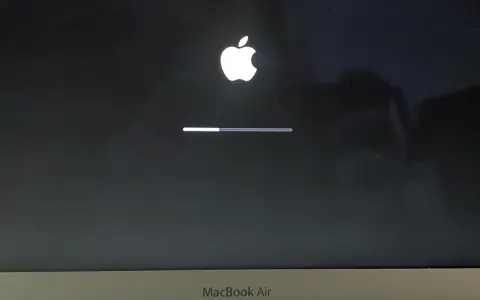 Ekran startowy MacBook Air z logo Apple i paskiem postępu, wskazującym ładowanie systemu macOS Monterey.