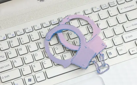 Różowe kajdanki na klawiaturze laptopa symbolizują problemy ze sklepem z aplikacjami.