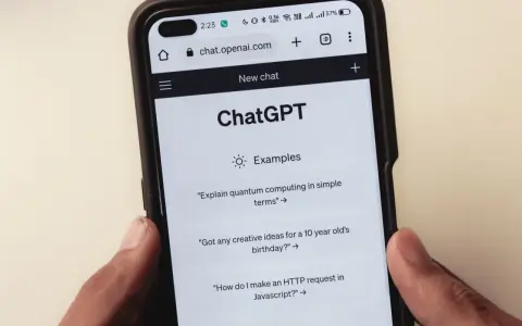 Na ekranie smartfona widać interfejs ChatGPT, gdzie użytkownik może zadawać pytania, np. o komputery kwantowe.