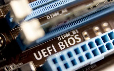 Zbliżenie na płytę główną z widocznym napisem "UEFI BIOS" i złączami RAM. W tle widać oznaczenie DIMM_A1, a poniżej DIMM_B1. Ten układ jest kluczowy dla bezpieczeństwa systemu, podobnie jak moduł **TPM 2.0**.