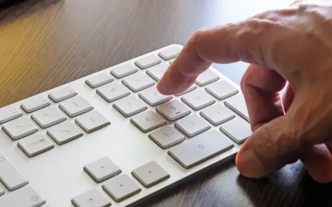 Dłoń naciska klawisz 8 na klawiaturze numerycznej.