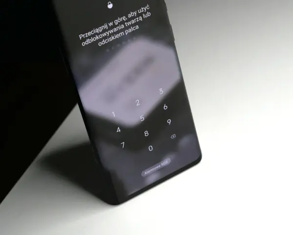 Ekran blokady Samsung z klawiaturą numeryczną i instrukcją "Przeciągnij w górę, aby użyć odblokowywania twarzą lub odciskiem palca". Pomoc, jak odblokować telefon Samsung, gdy zapomni się kodu.