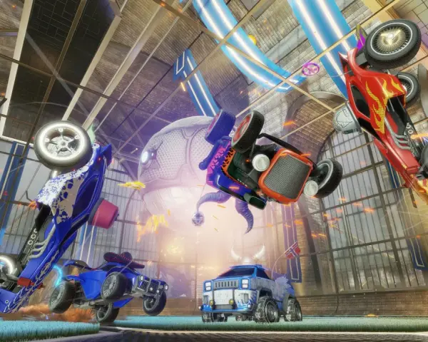 Trzy samochody z gry Rocket League w powietrzu, jeden czerwony, jeden niebieski i jeden pomarańczowy, na tle hali.