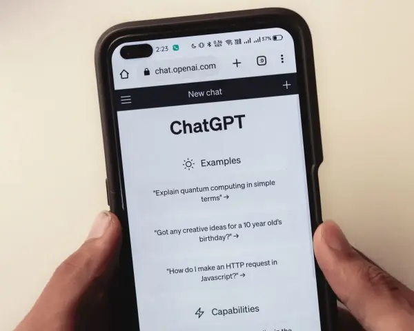 Na ekranie smartfona widać interfejs ChatGPT, gdzie użytkownik może zadawać pytania, np. o komputery kwantowe.