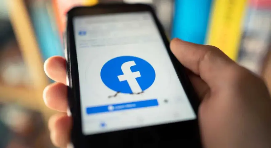 Dłoń trzyma smartfon z logo Facebooka. Chcesz wiedzieć, jak usunąć FB?