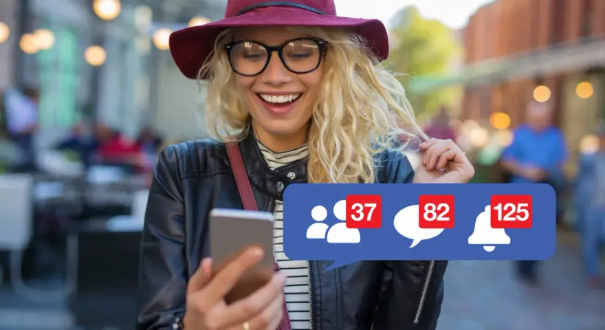 Szukasz informacji, jak usunąć konto na FB na telefonie? Uśmiechnięta dziewczyna z telefonem i powiadomieniami na ekranie.