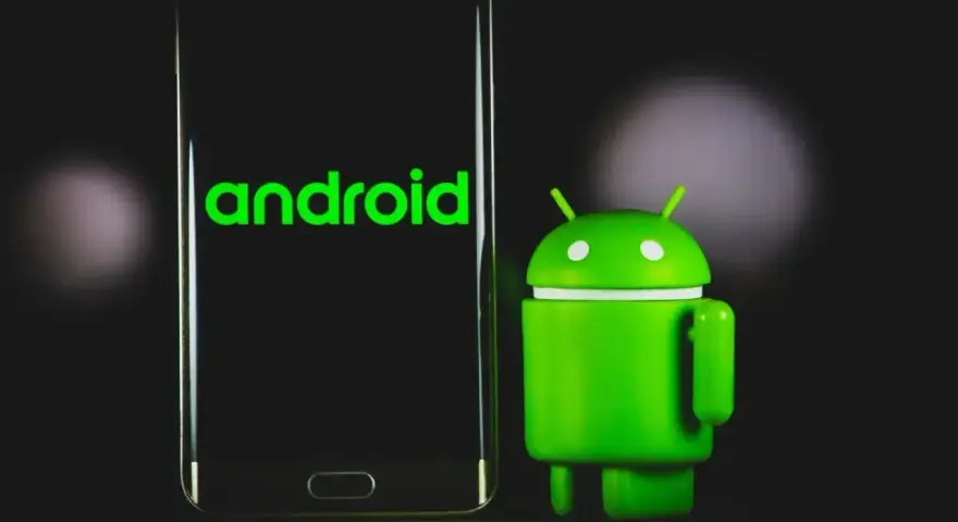 Zielony robot Android obok telefonu z logo Android 13.
