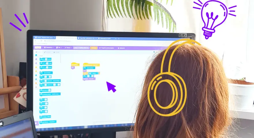 Dziewczynka w słuchawkach tworzy kod w Scratch po polsku, ucząc się programowania.