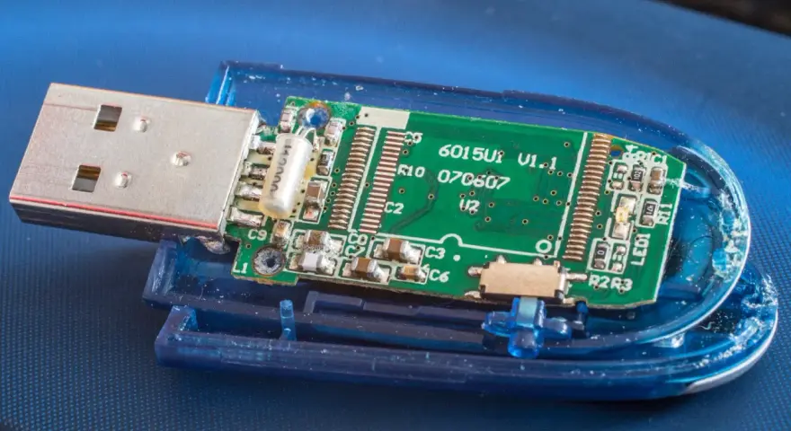 Rozłożony pendrive z widoczną zieloną płytką drukowaną i złączem USB. Widać elementy elektroniczne, oznaczenia jak "6015U1 V1.1" i "exfat" (choć nie widać go na obrazku, można założyć, że jest to format pliku).