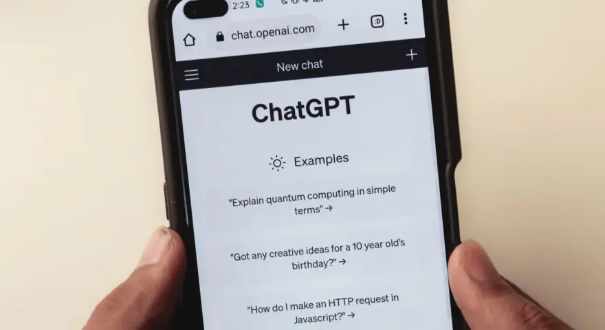 Na ekranie smartfona widać interfejs ChatGPT, gdzie użytkownik może zadawać pytania, np. o komputery kwantowe.