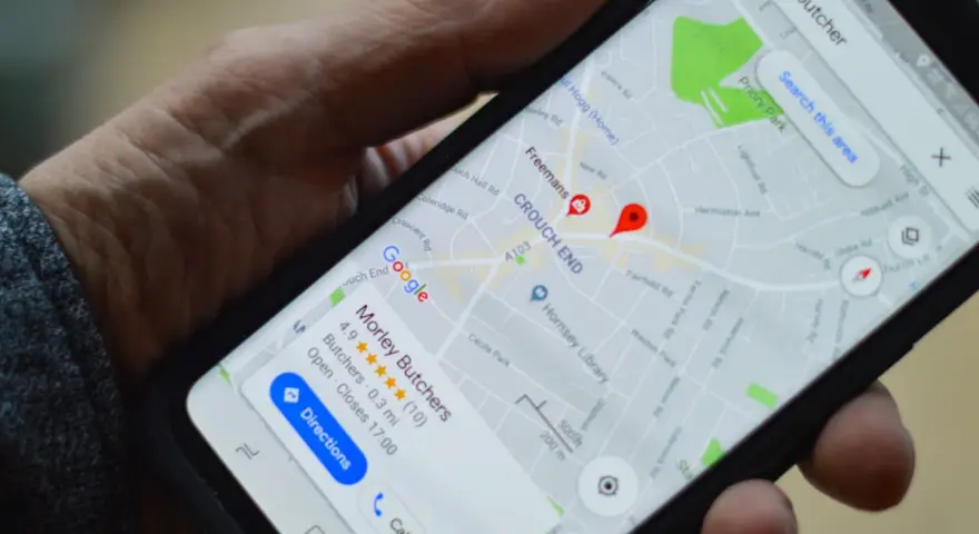 Dłoń trzyma smartfon z mapą Google, na której widoczny jest czerwony pinezka i nazwa "Morley Butchers".