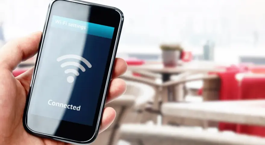 Dłoń trzyma smartfon z ikoną Wi-Fi i napisem "Connected".
