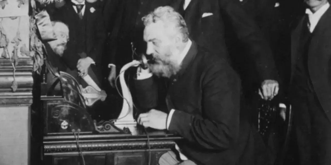 Alexander Graham Bell, który wynalazł telefon, testuje swoje urządzenie.