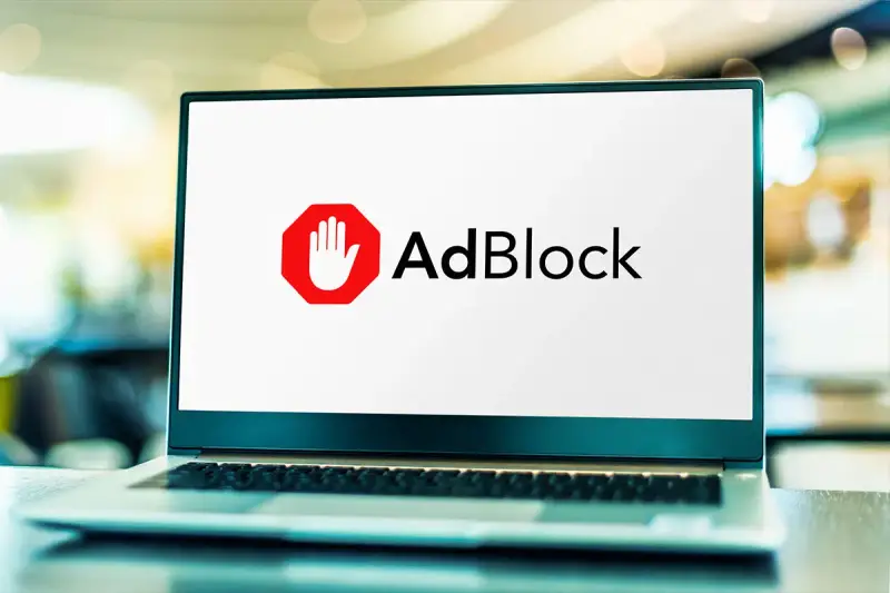Laptop z logo AdBlock. Dowiedz się, jak wyłączyć adblocka, aby zobaczyć treści.